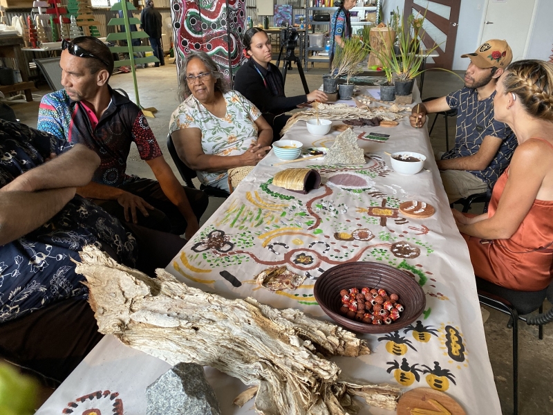 A group of people sits casually at a long table