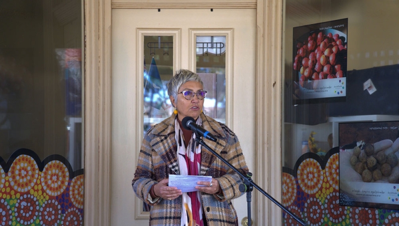 A woman stands at a microphone