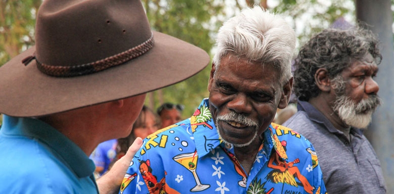 Three men  - two are talking - the other is moving away in the background