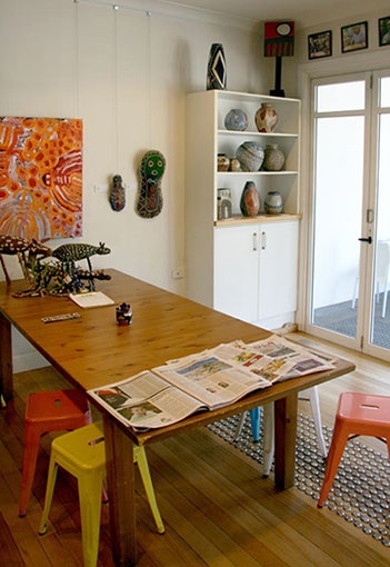 A cafe table with artworks on the wall and shelves behind