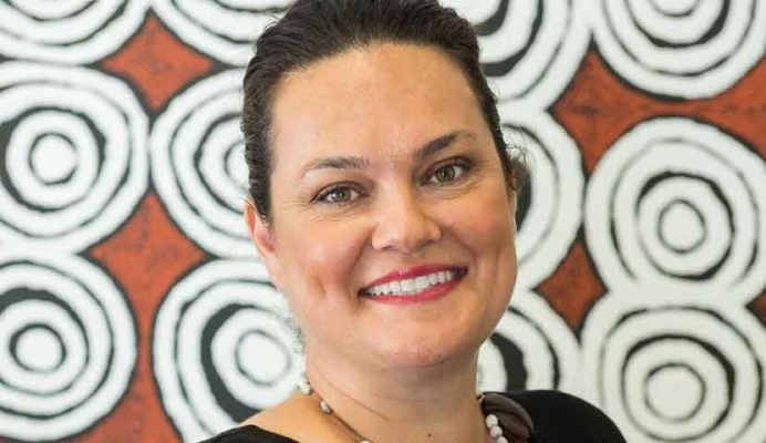 A woman smiles at the camera