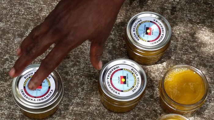 A hand touches one of several jars