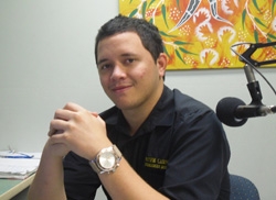 A man sits next to a microphone