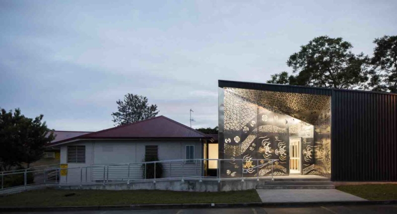 An old house is joined to a larger, modern building