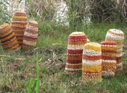 Eight colourful dome-shaped sculptures in a group of 3 and a group of 5 in an outdoor setting