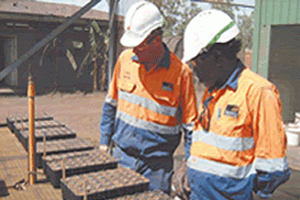 Two men in hi vis and hard hats look at equipment