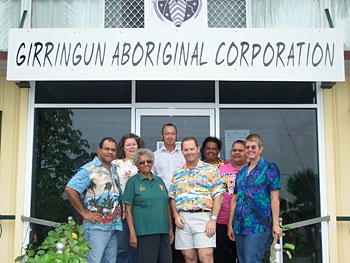 Eight people stand outside a building with the sign Girringun Aboriginal Corporation behind them