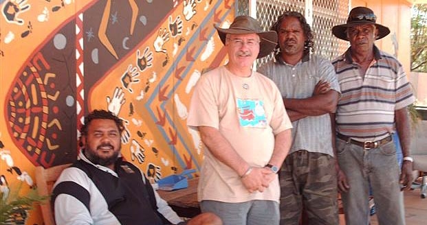 A group of people next to a colourfully painted wall
