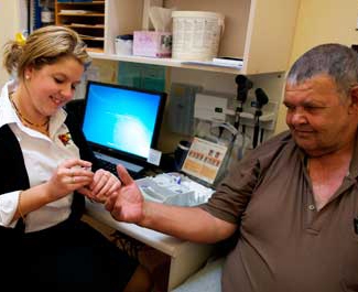 A nurse holds a man's hand in a medical office