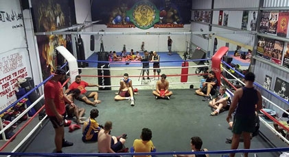 A number of people sit in a boxing ring