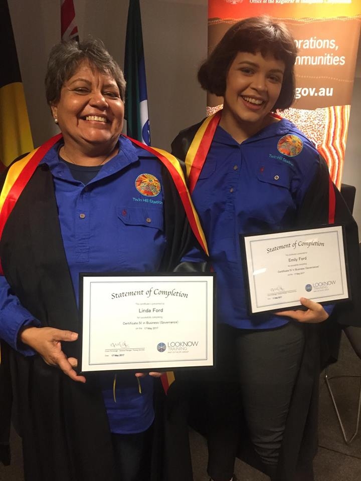 Two women holding certificates