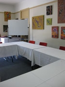 A room with empty tables and a whiteboard