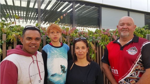 Four people smile at the camera