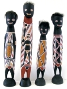 Four wooden sculptures of men with Aboriginal artwork on their torsos