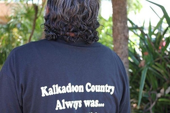 A person's back. Their dark blue shirt reads Kalkadoon Country Always was...