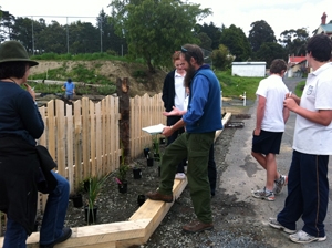 A group of people standing at a garden bed