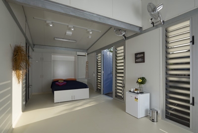 A spacious room with a bed at the far end