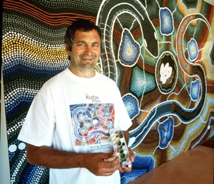 A man stands next to a large mural