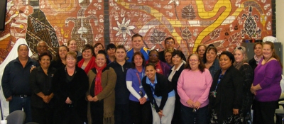 A group of people in front of a colourful wall