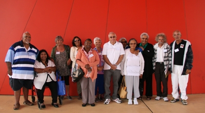 A group of men and woman standing in front of a red wall