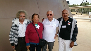 Four people stand in front of a wall
