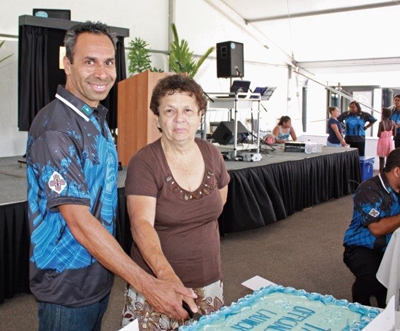 A man and a woman cutting a large cake