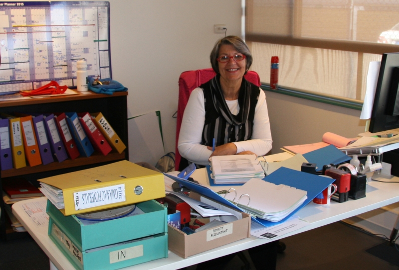 A woman sits at an office desk