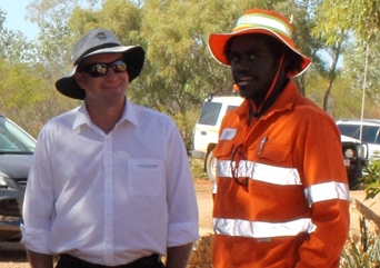 Two men pose for the camera. One of them is wearing hi vis