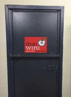 A door with a red sign saying mai wiru