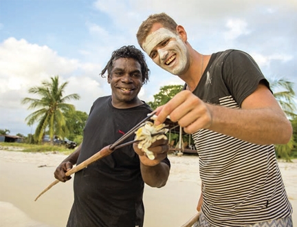 Two men hold a fish on the end of a spear