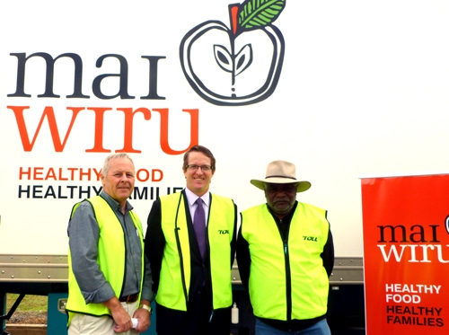 Three men wearing hi vis pose in front of a truck with a mai wiru logo on it