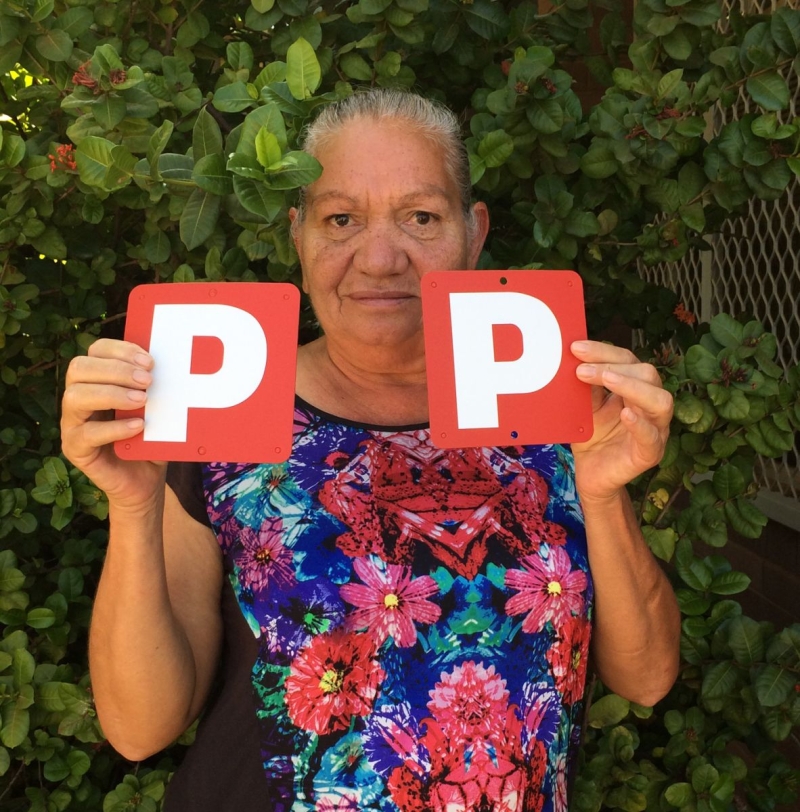 A woman holds up 2 red P plates