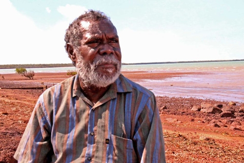 Portrait of a man with red dirt in the background